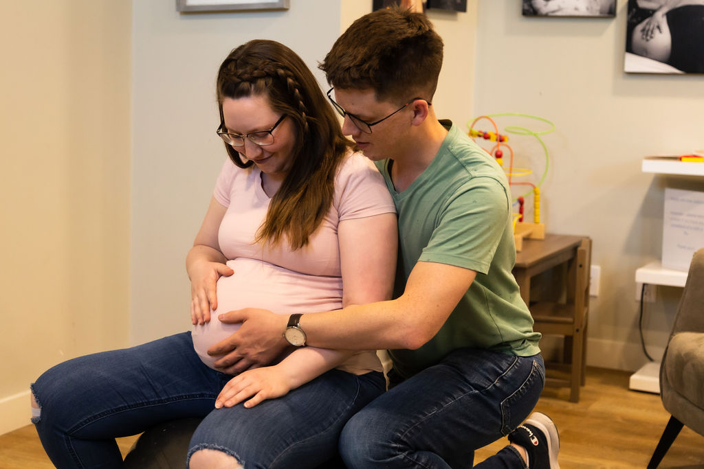 Pregnant couple looking at belly