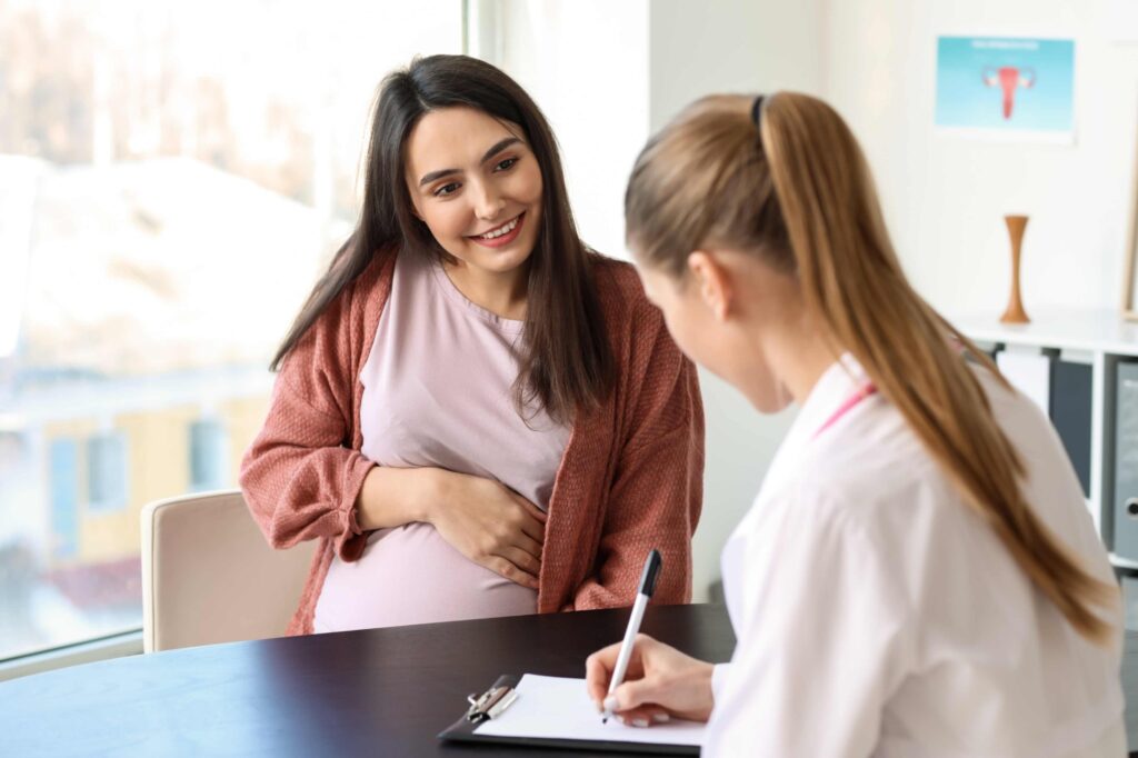 Pregnant woman chatting with doula taking notes