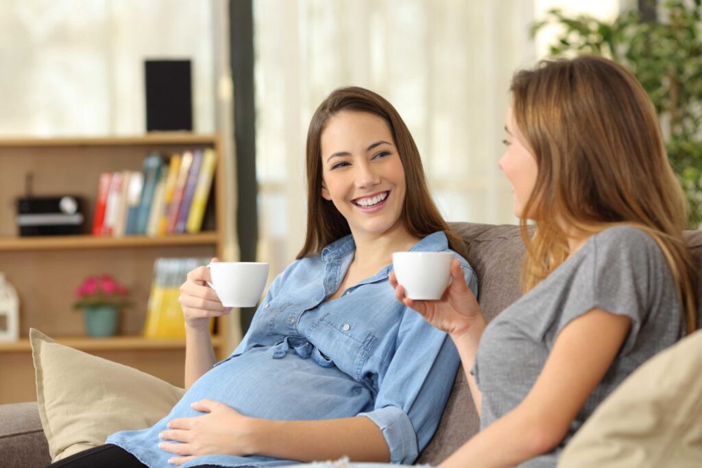 Pregnant woman having tea with a doula