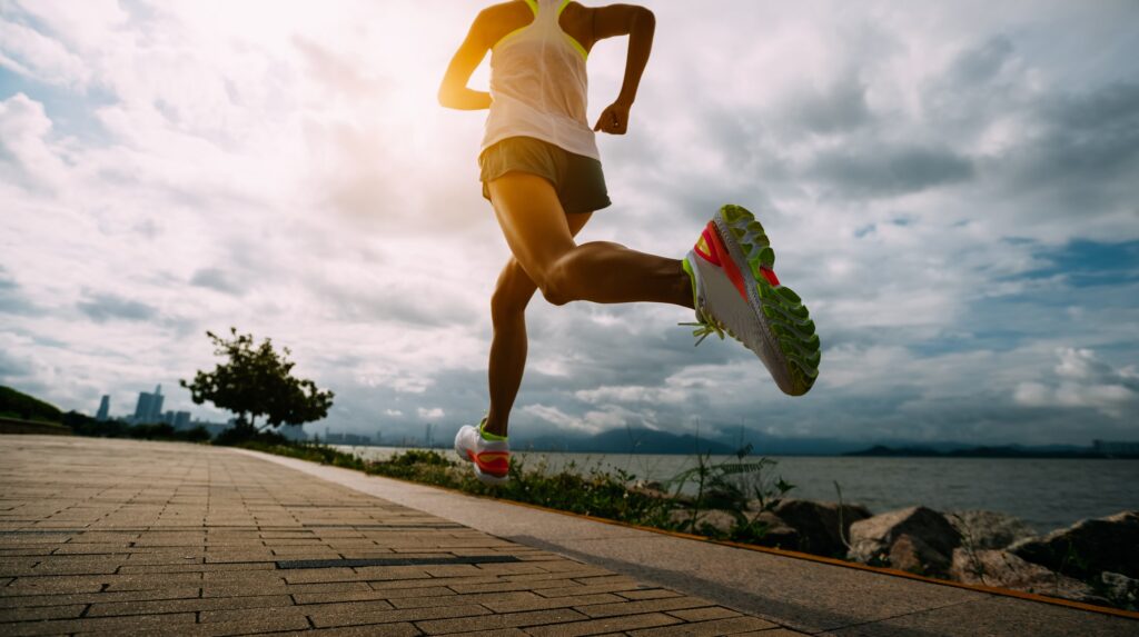 Woman running on path beside water