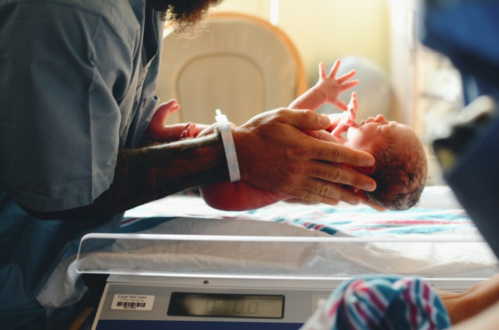 Midwife putting baby on scale