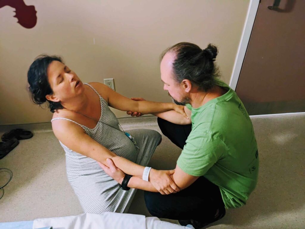 Woman squatting in labor with husband's support